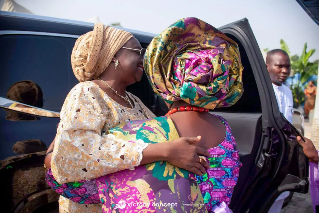 Guests in elaborate gold and jewel-toned gele headwraps at a traditional event, styled by Victony Event Planners