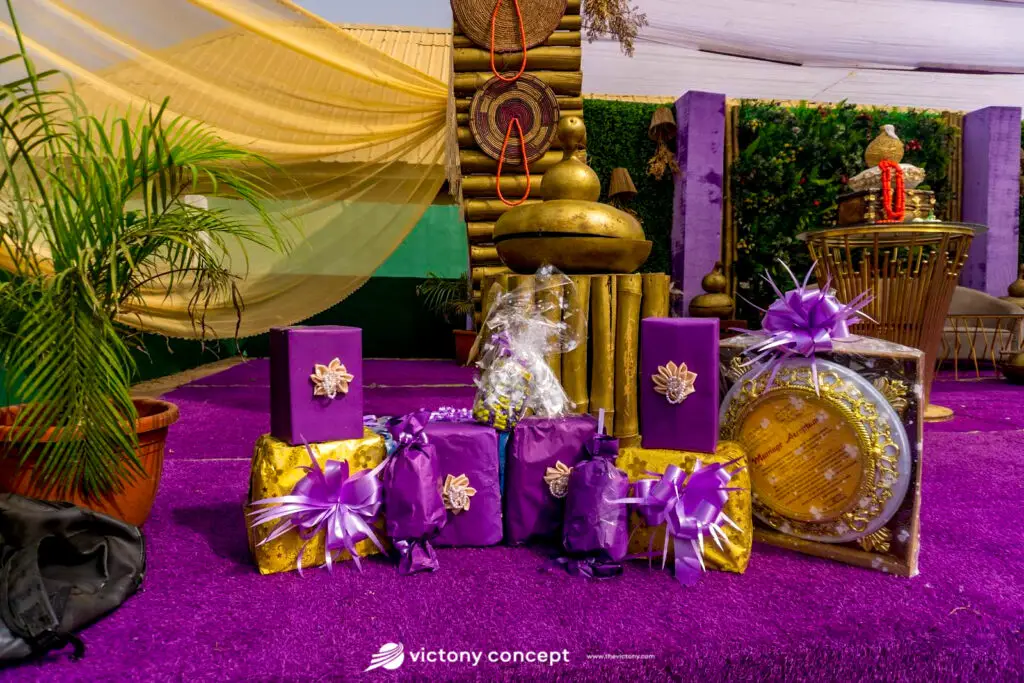 Purple and gold wrapped gifts displayed on a decorated table at a traditional wedding, styled by Victony Event Planners